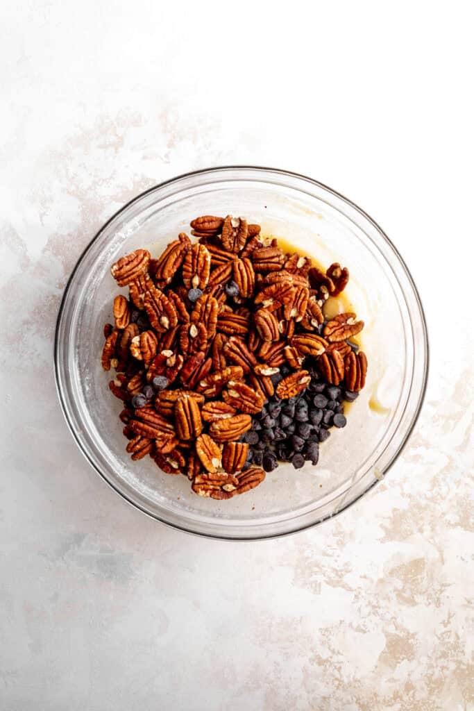 Glass bowl of pecans and chocolate chips.