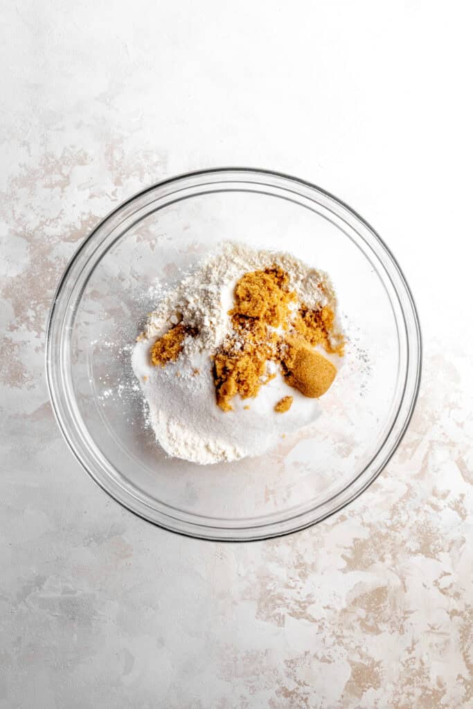 Glass bowl filled with flour, sugar and brown sugar.