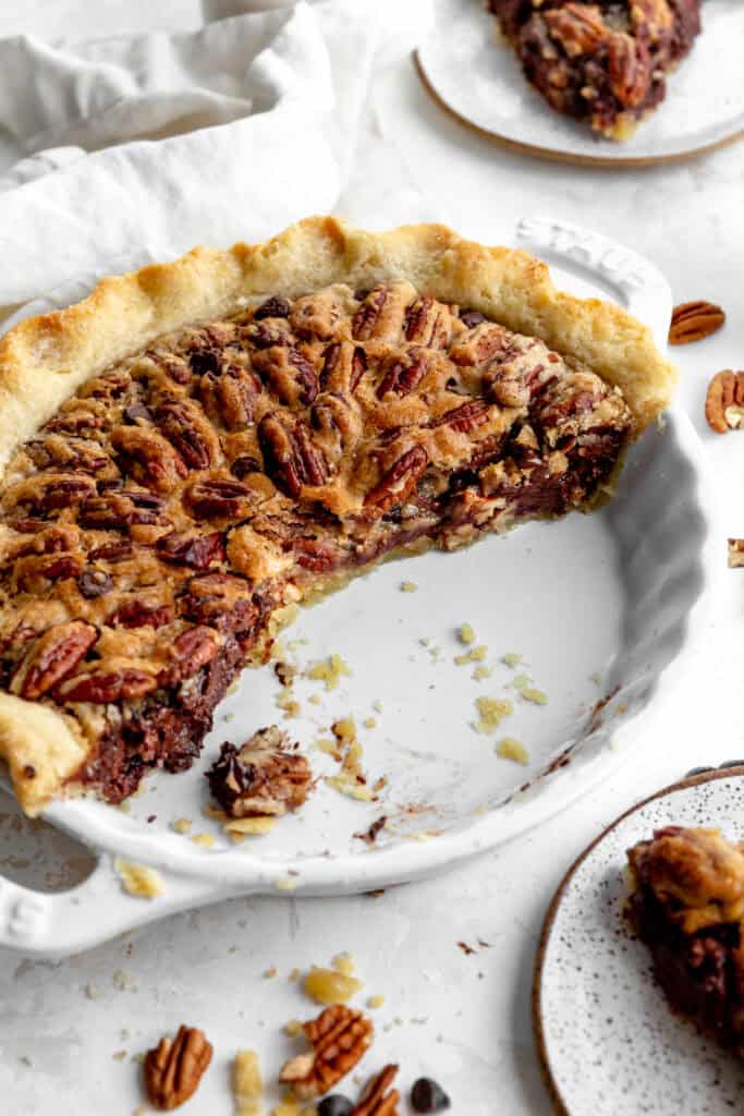 Dish of chocolate pecan pie with slices missing.