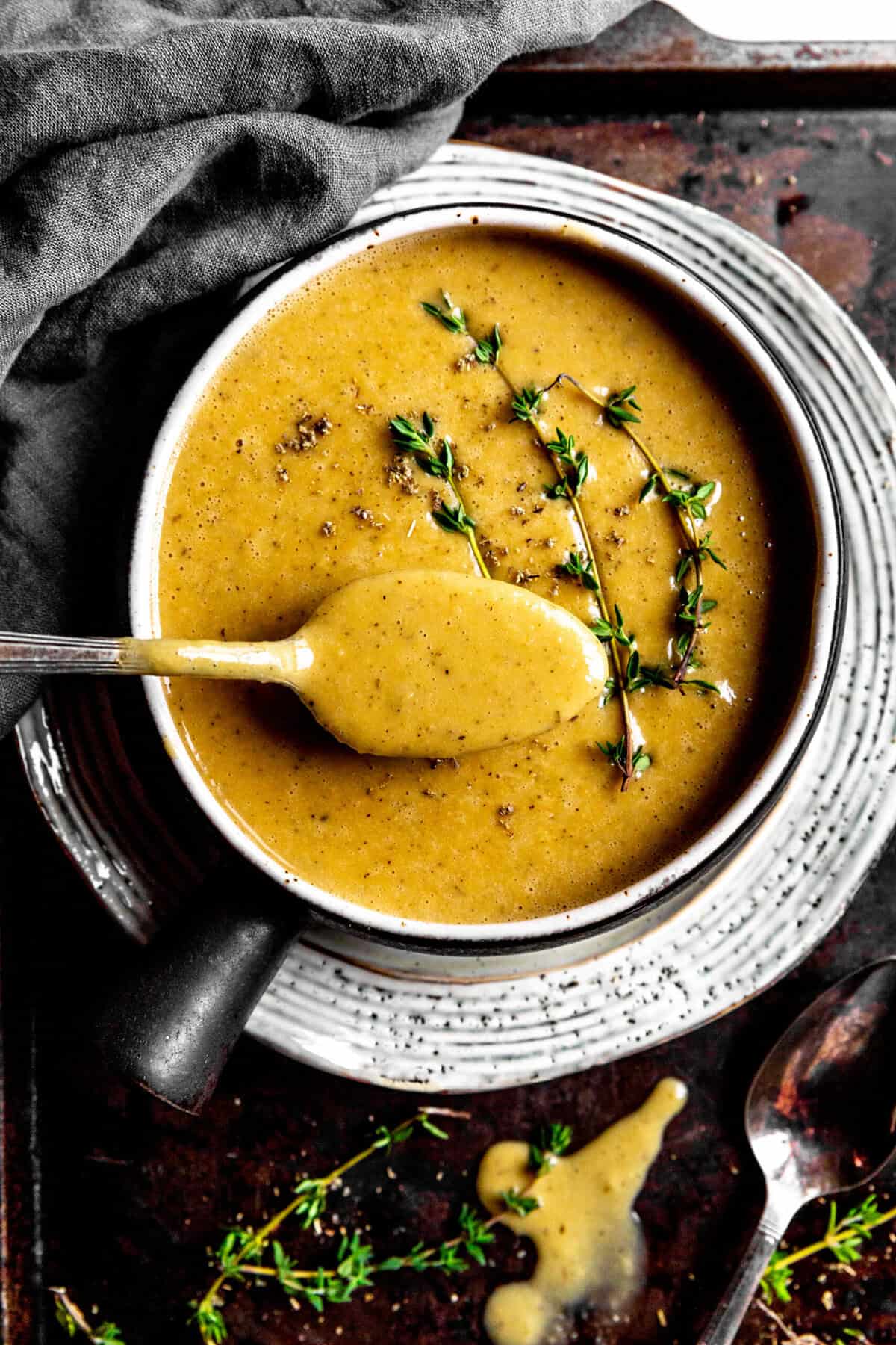 Spoonful of gravy over a bowl of gravy.