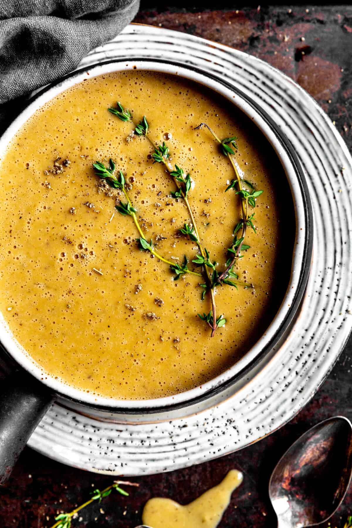 Bowl of vegan gravy topped with fresh thyme.