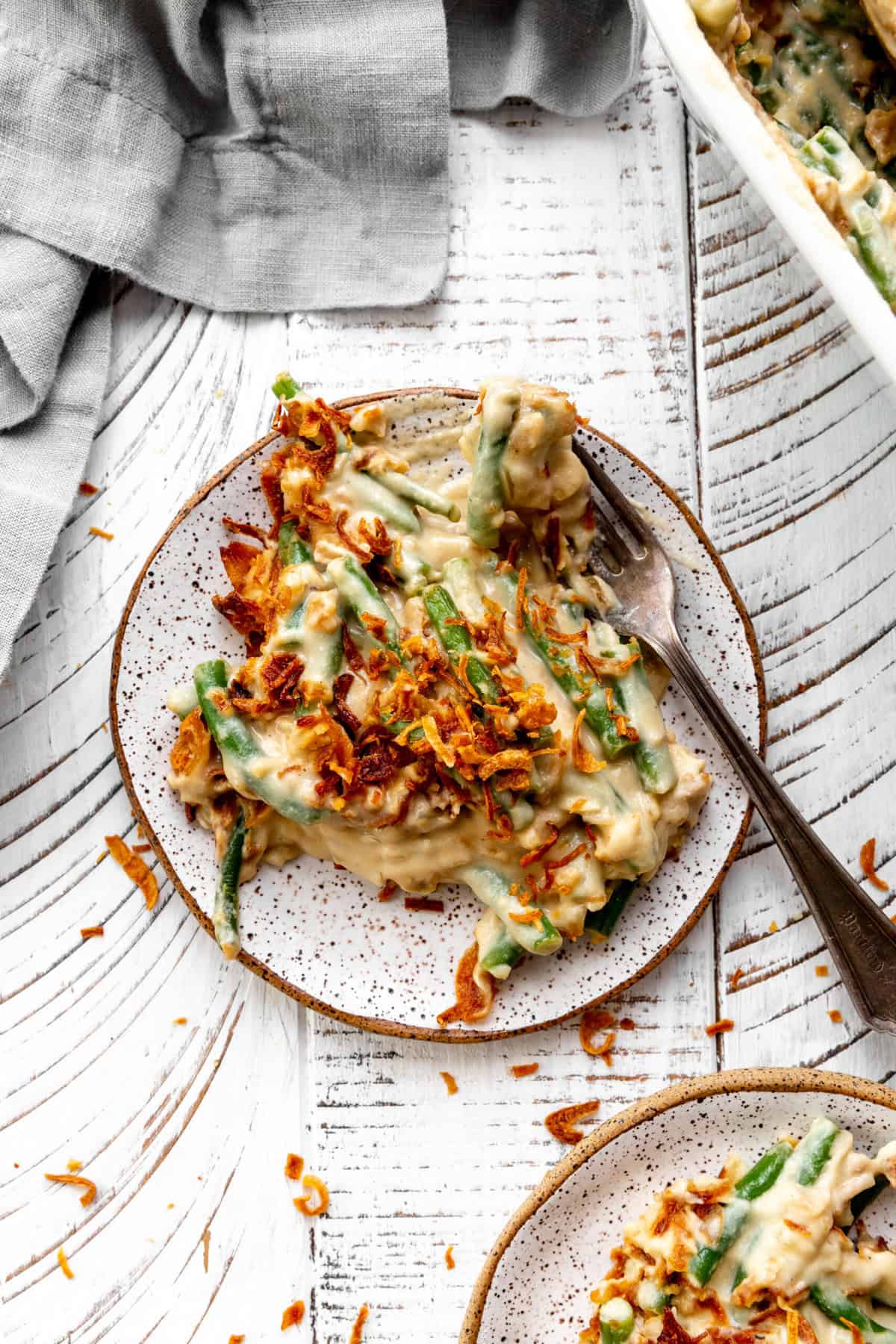 Fork digging into a plate of green bean casserole.