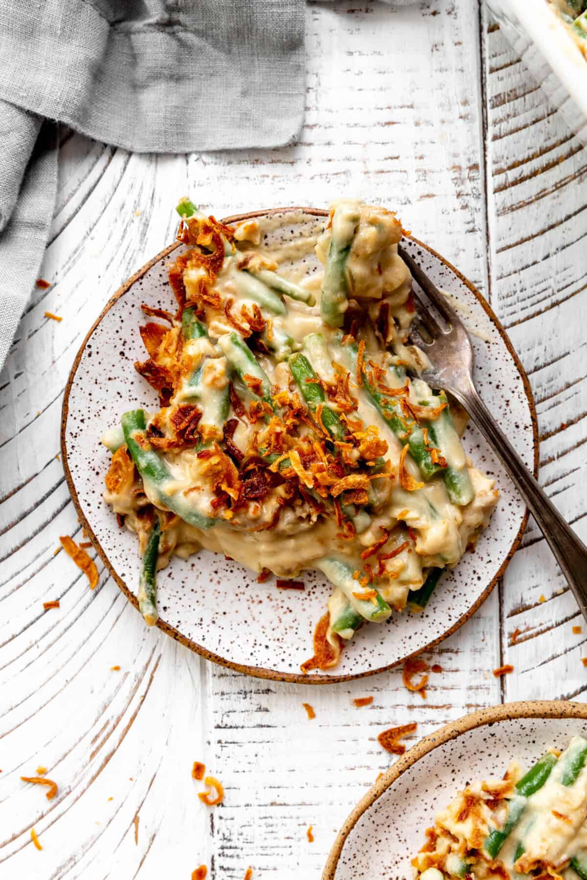 Fork digging into a plate of green bean casserole.