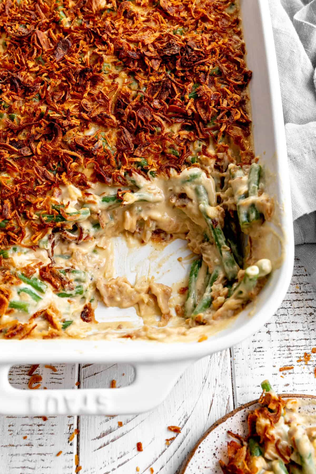 Dish of green bean casserole with some missing.