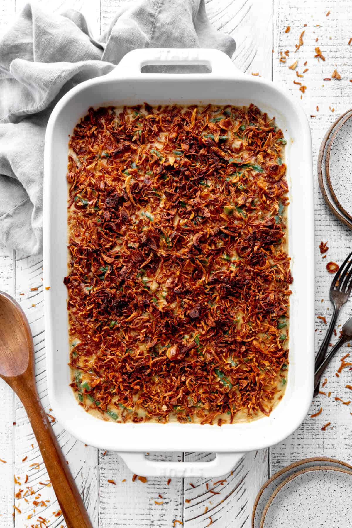 Green bean casserole, a linen napkin and a wooden spoon.
