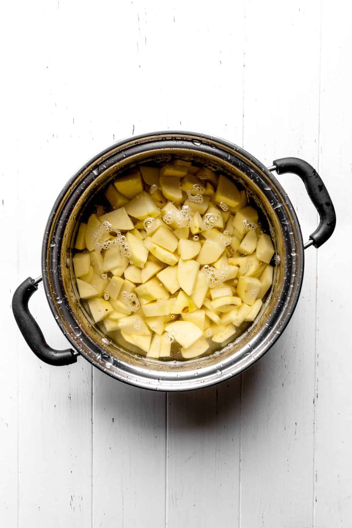 Cubed potatoes covered in water in a pot.