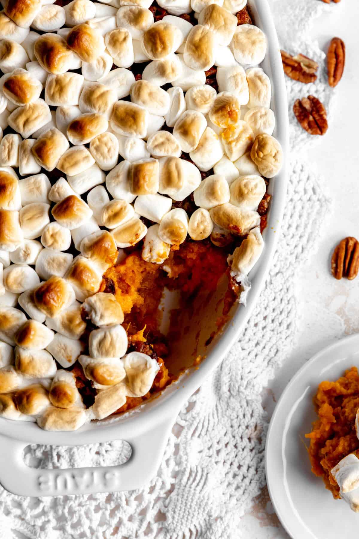 Sweet potato casserole dish and some scattered pecans.