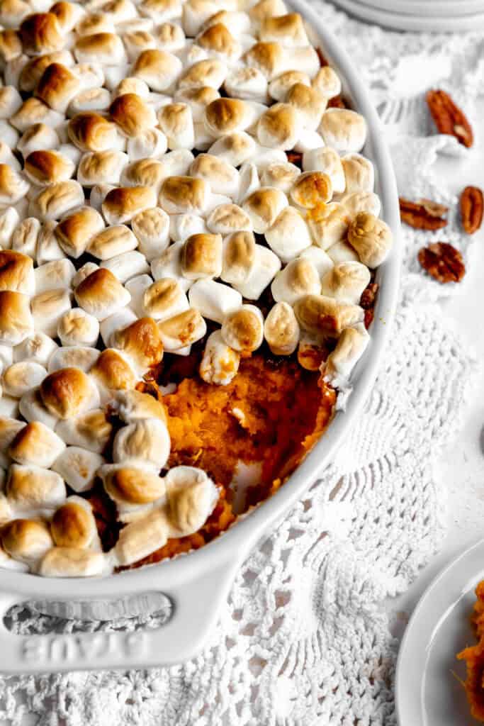 Sweet potato casserole dish and some scattered pecans.
