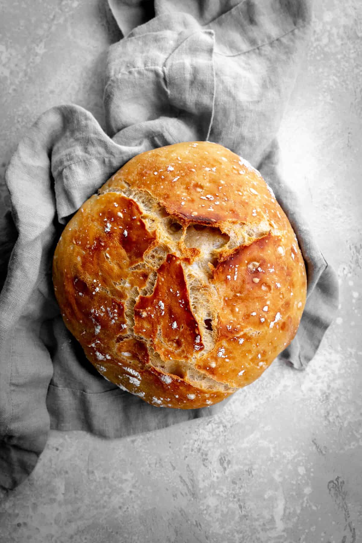 Loaf of bread on a gray linen napkin.