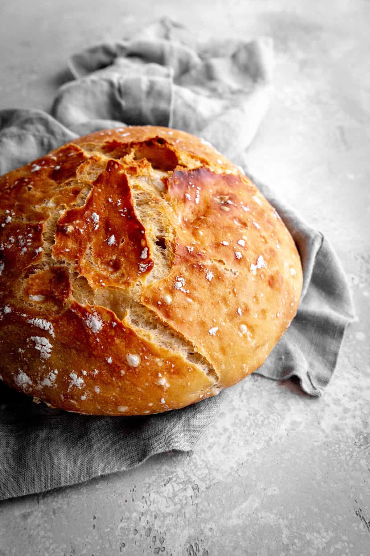 Loaf of bread on a gray linen napkin.