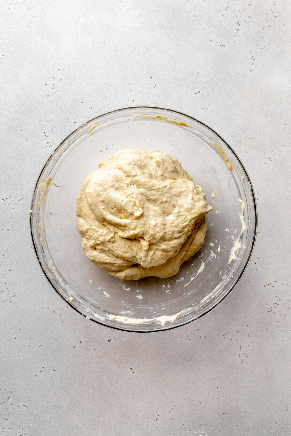 Stretched and folded bread dough in a glass bowl.