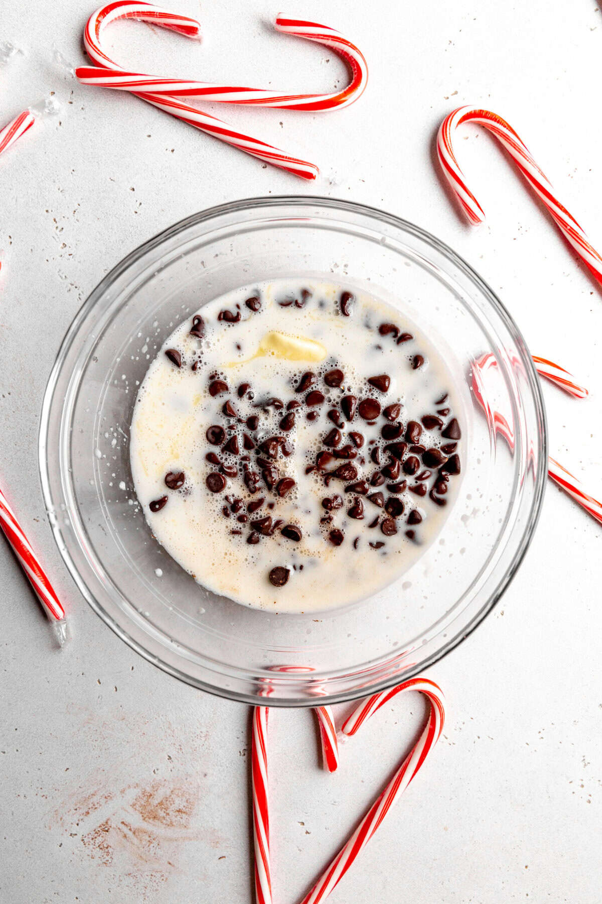 Chocolate chips and milk in a glass bowl.