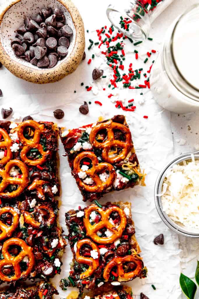 Christmas 7 layer bar, a cup of milk and scattered red and green sprinkles.