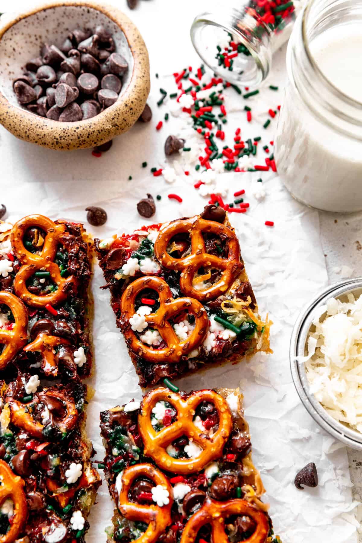 Christmas 7 layer bar, a cup of milk and scattered red and green sprinkles.