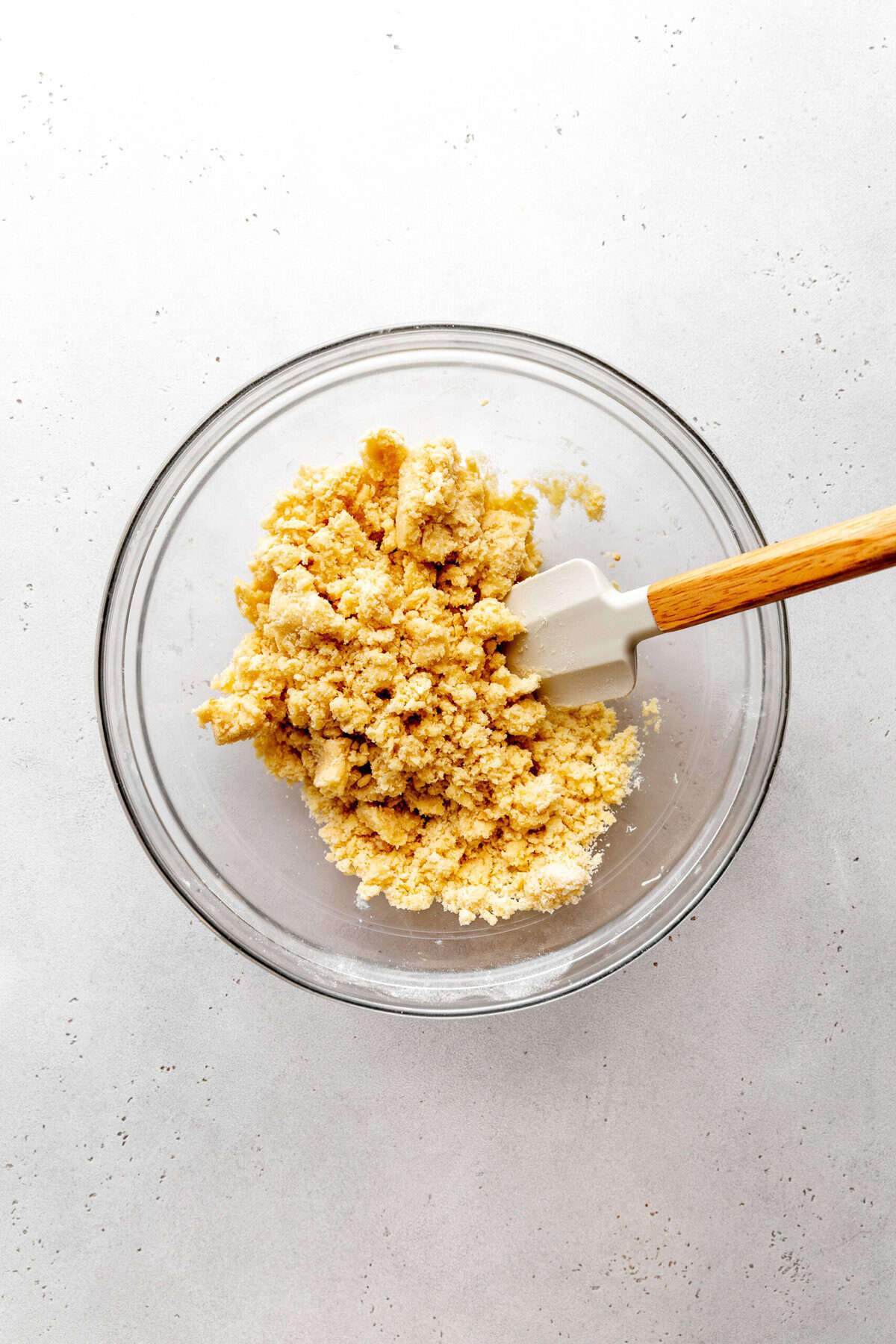 Glass bowl of sugar cookie dough and a rubber spatula.