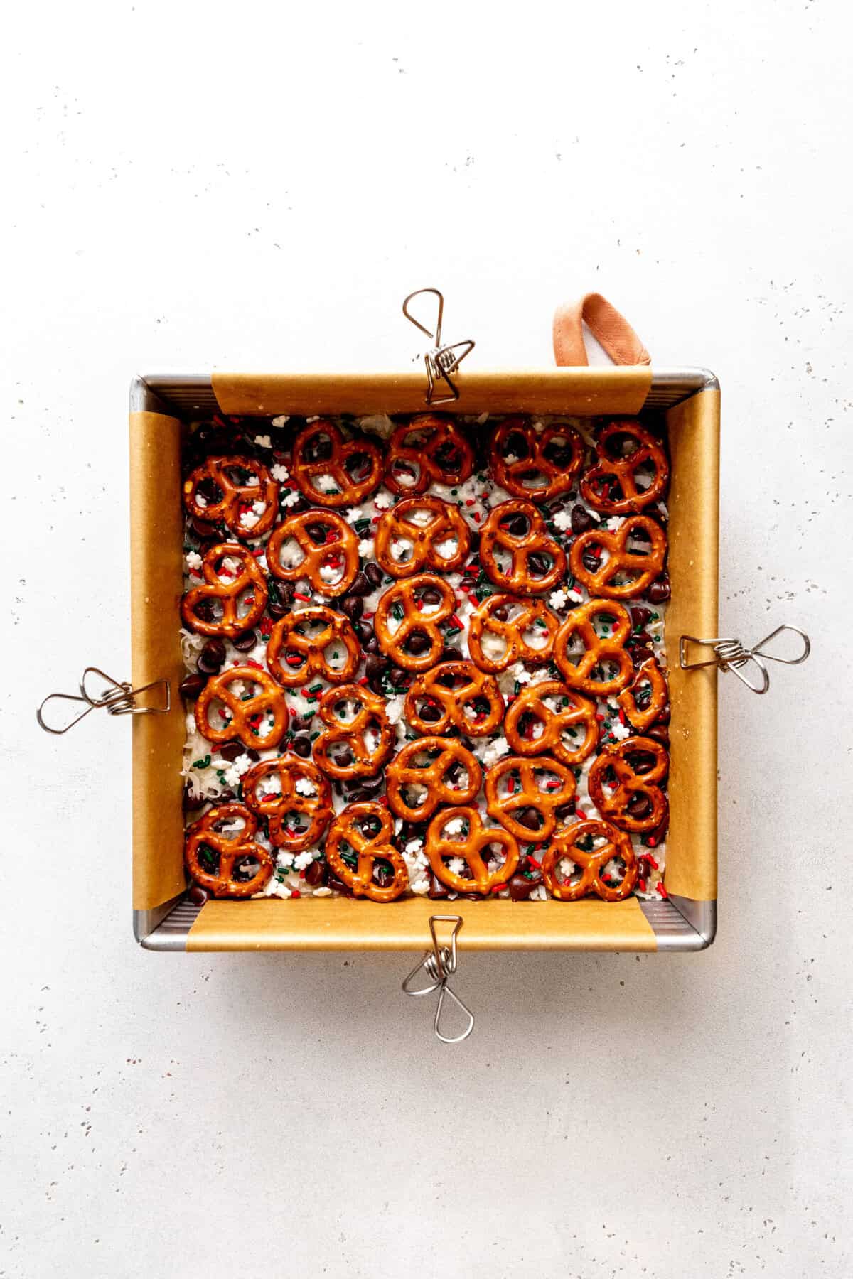 Unbaked Christmas 7 layer bars in a square pan.