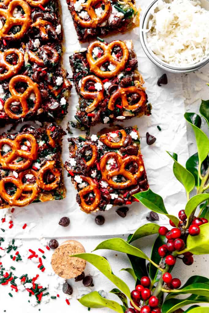 Christmas 7 layer bars, a cup of coconut and a branch of holly.