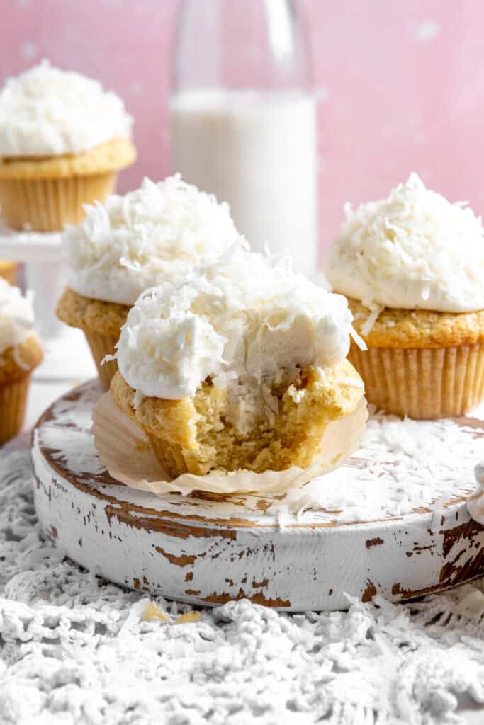 Coconut cream cupcake with a bite taken out of it.