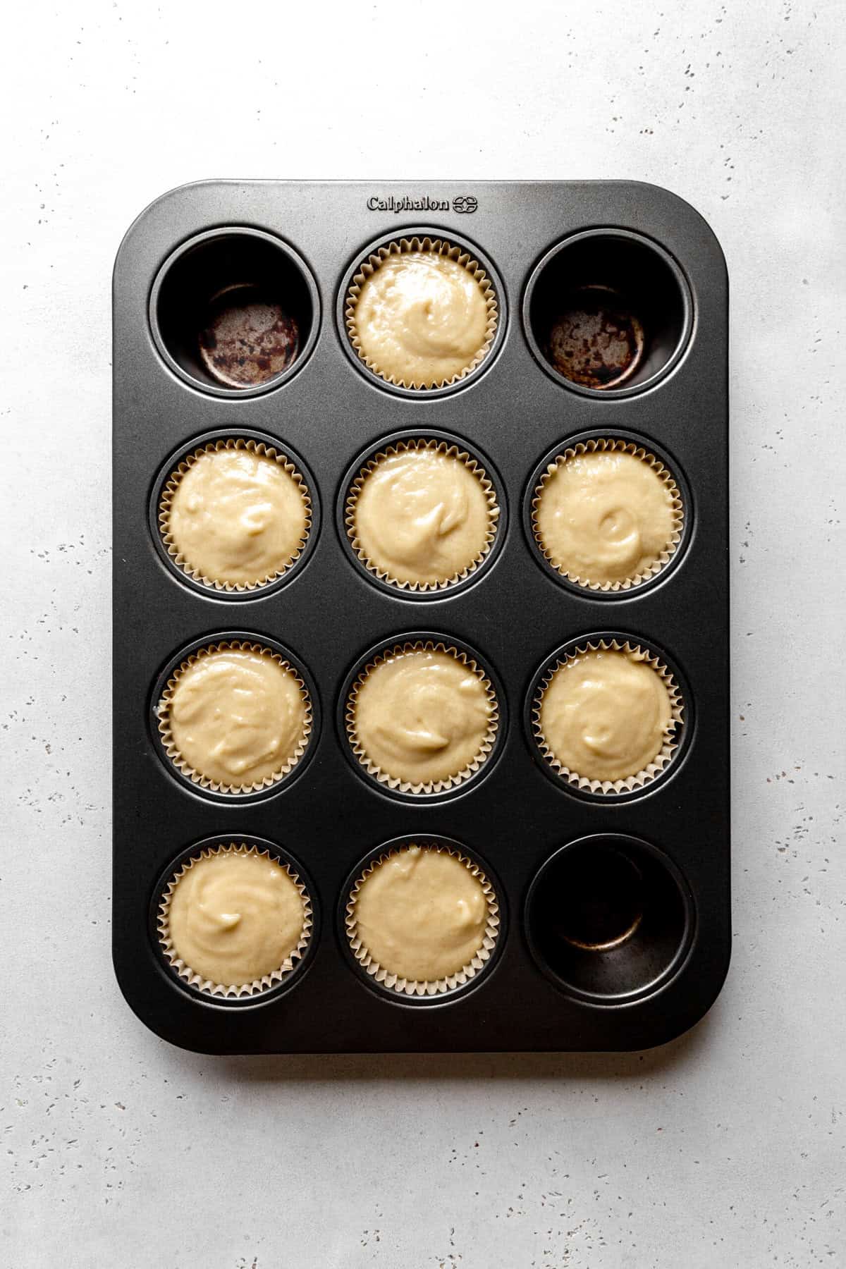 Unbaked coconut cupcakes in a cupcake pan.