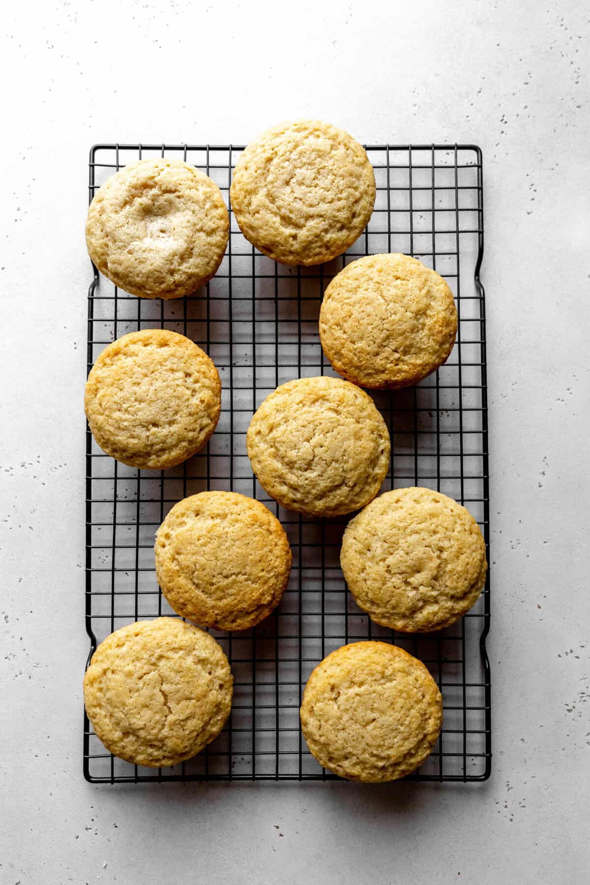 Baked coconut cupcakes on a cooling rack.