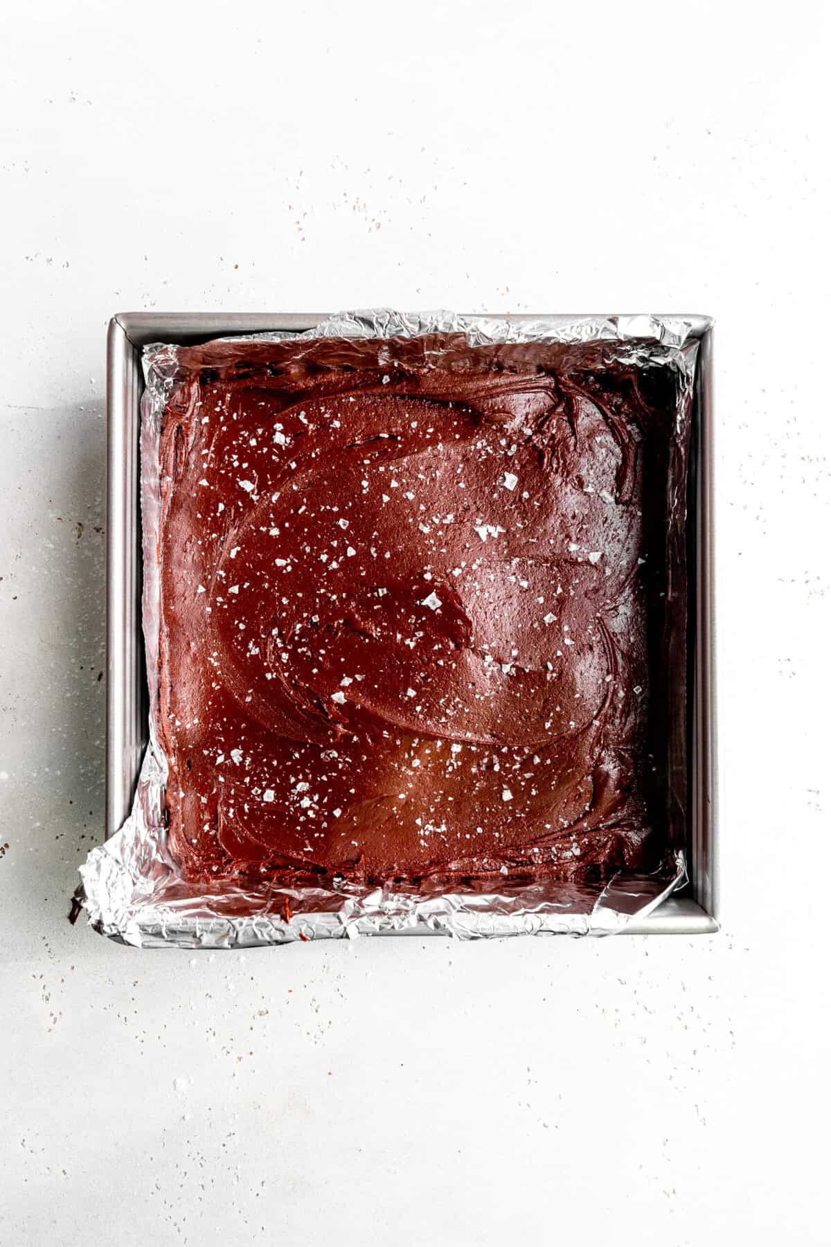 Fudge in a square pan topped with flaky salt.