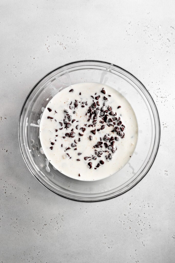 Glass bowl of chocolate chips and cream.