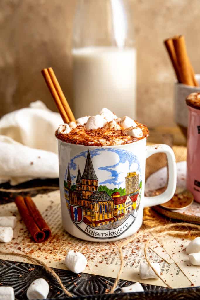 Mug of Mexican hot chocolate garnished with a cinnamon stick.