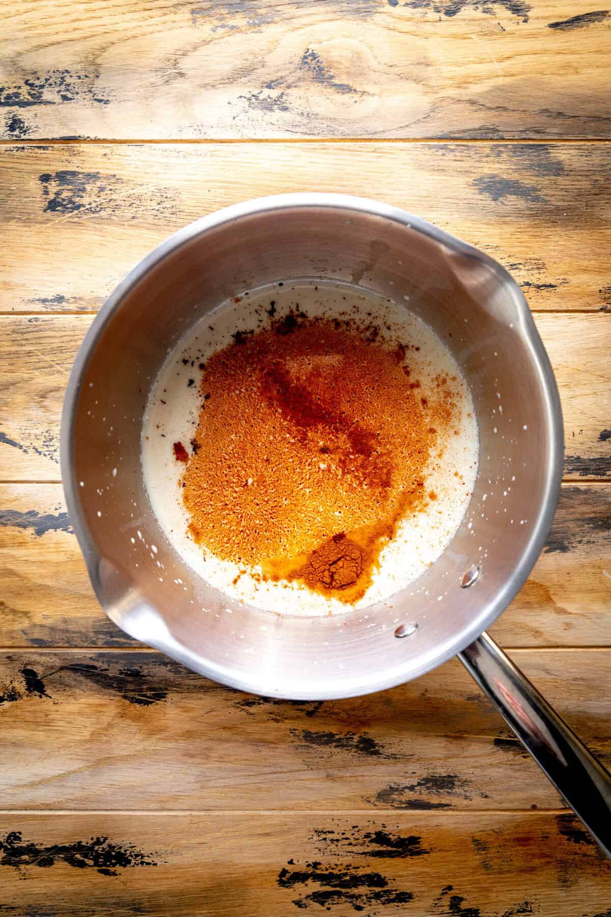 Oat milk, cinnamon and chocolate chips in a saucepan.