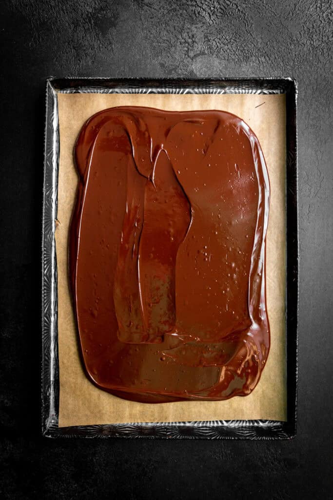 Chocolate spread out in a thin layer on a baking sheet.