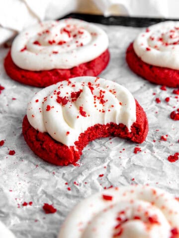 Red velvet cake cookie with a bite taken out of it.