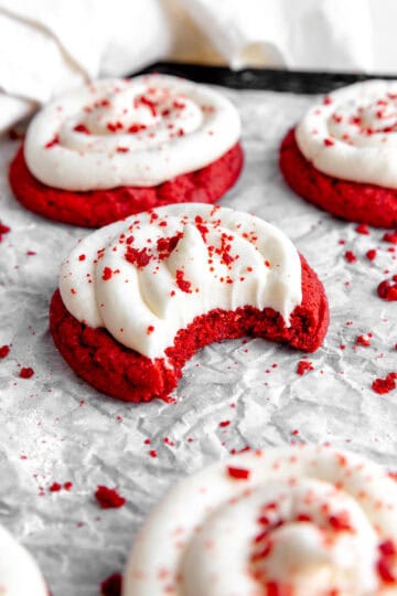 Red velvet cake cookie with a bite taken out of it.