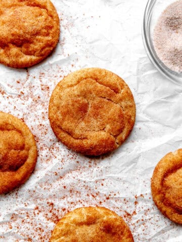 Vegan snickerdoodles and a bowl of cinnamon and sugar.