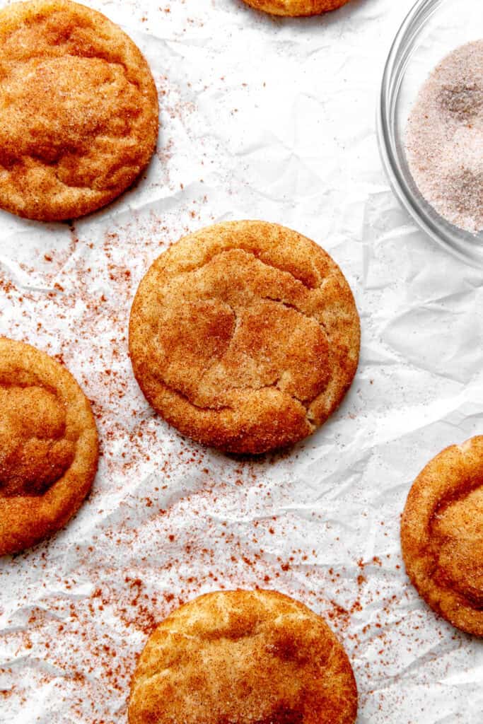 Vegan snickerdoodles and a bowl of cinnamon and sugar.