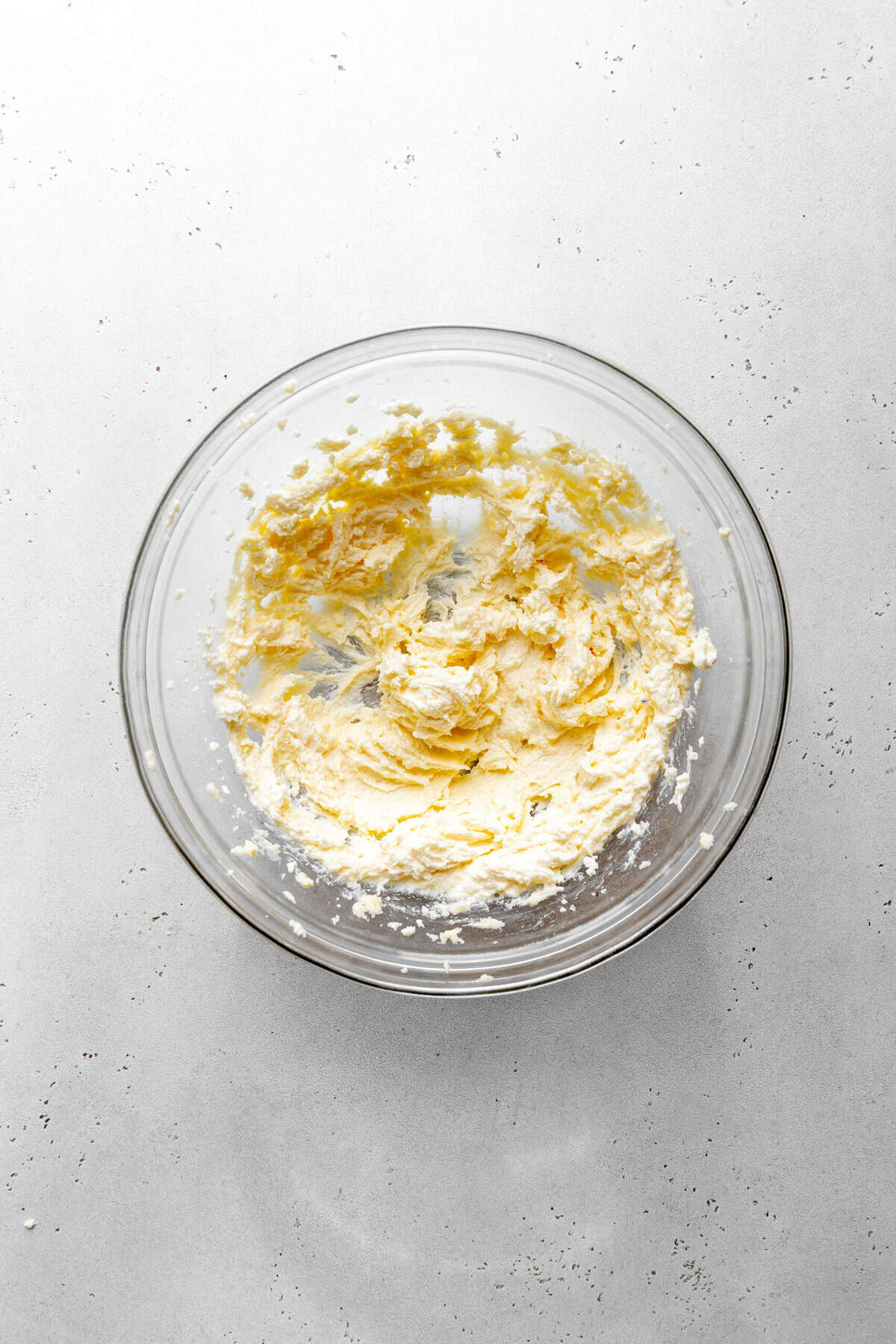 Glass bowl of creamed butter and sugar.