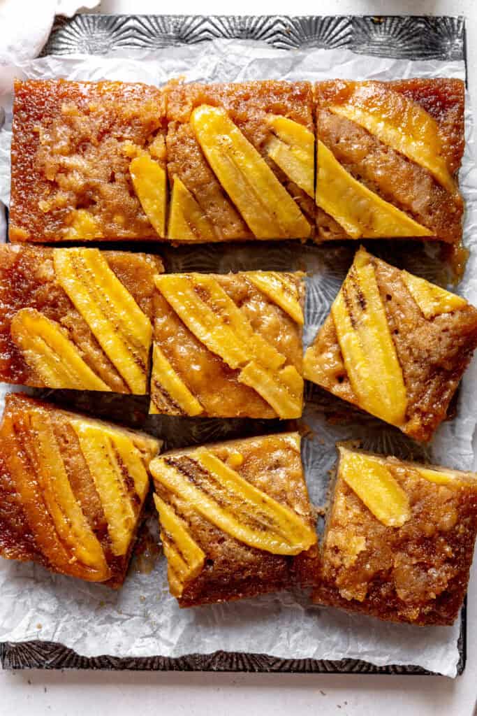 Sliced banana upside down cake on a baking sheet.