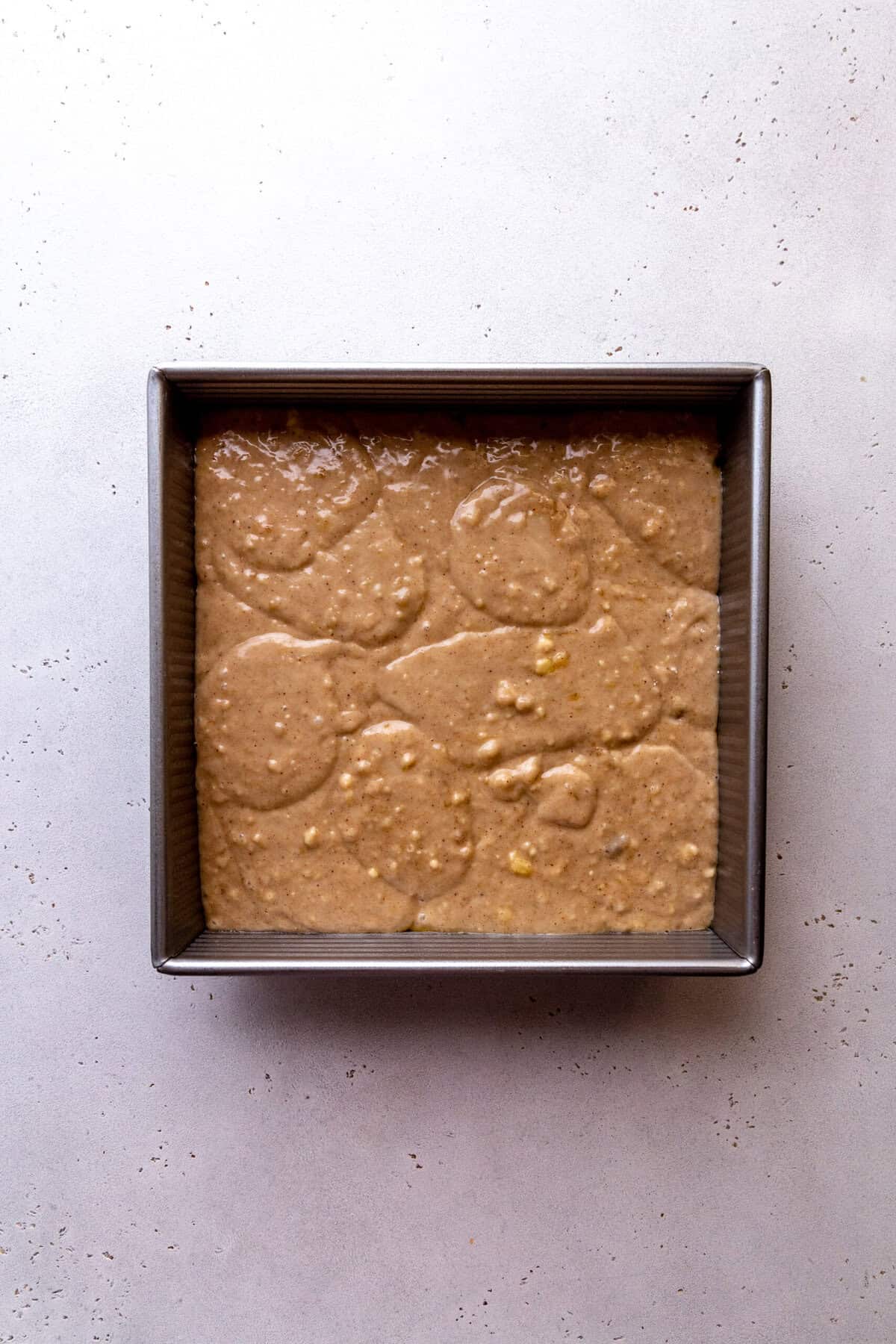 Unbaked banana upside down cake in a square pan.