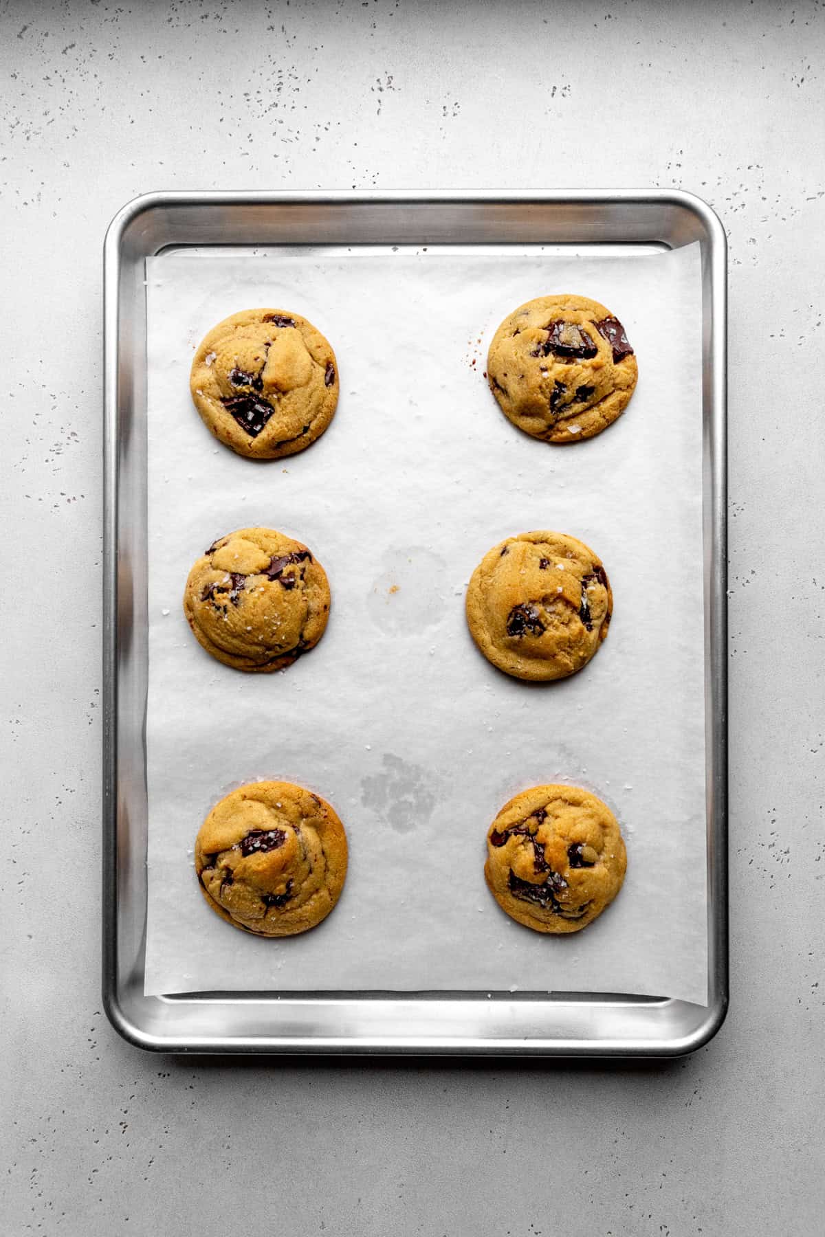 Baked chocolate chip cookies on a baking sheet.