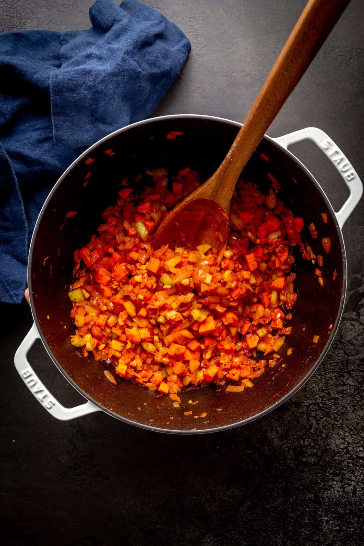 Large pot full of chopped onions, celery, carrots and tomato paste.
