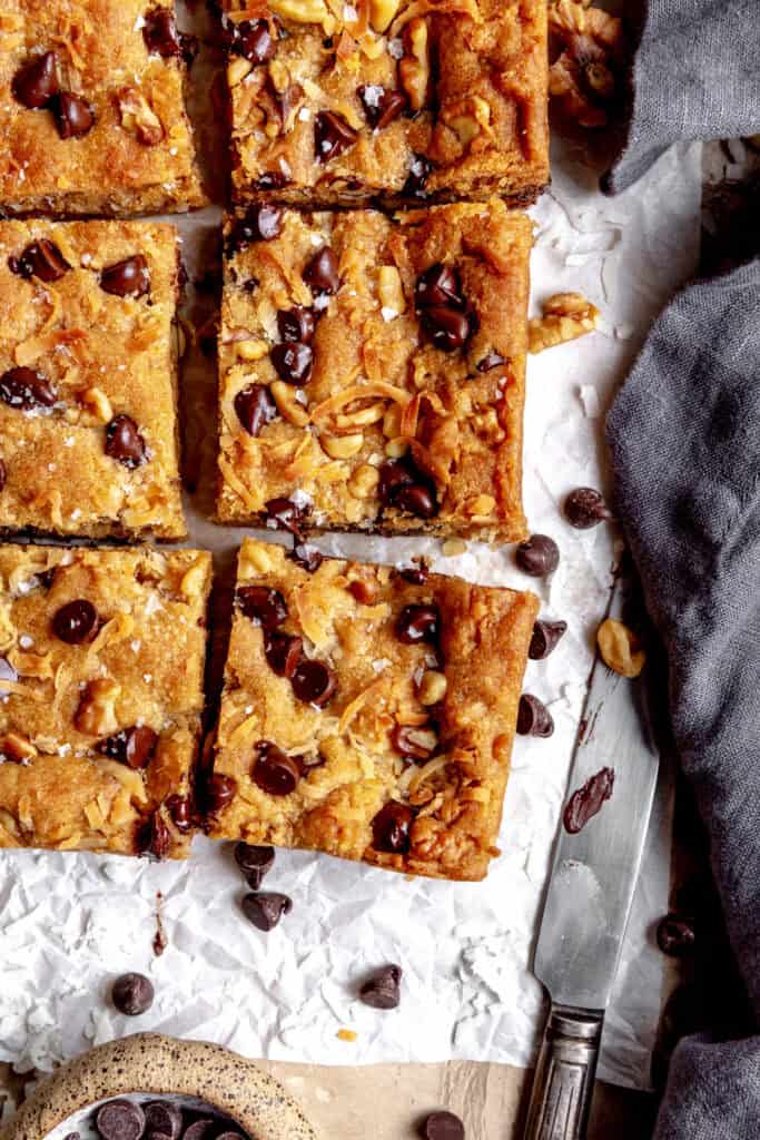 Blondies cut into squares, a linen napkin and a knife.
