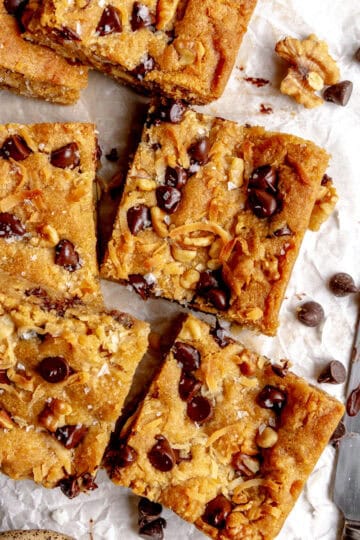 Vegan blondies on parchment paper and a knife.