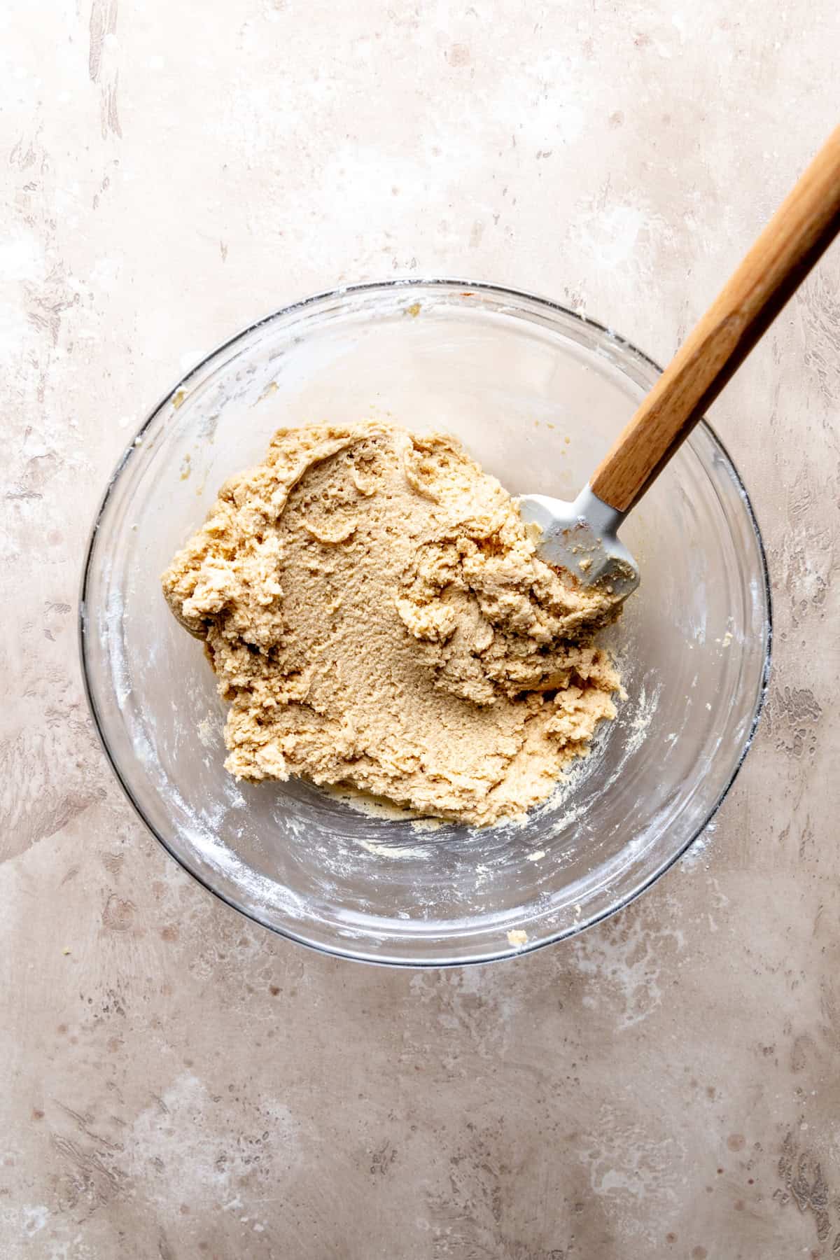 Glass bowl of blondie dough with a rubber spatula.