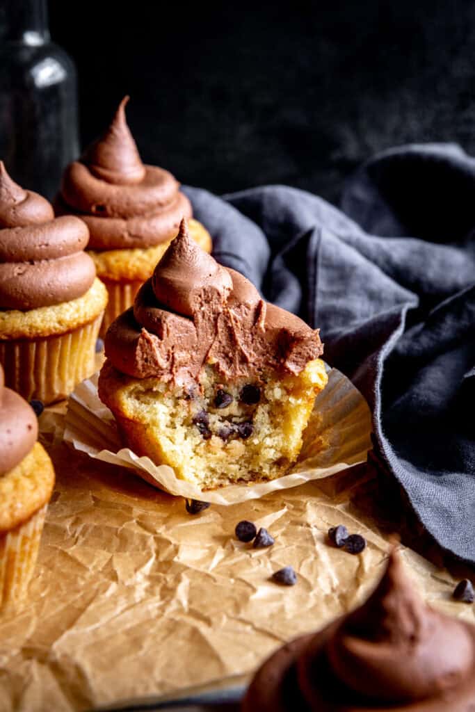 Cookie dough cupcakes with chocolate frosting and a linen napkin.