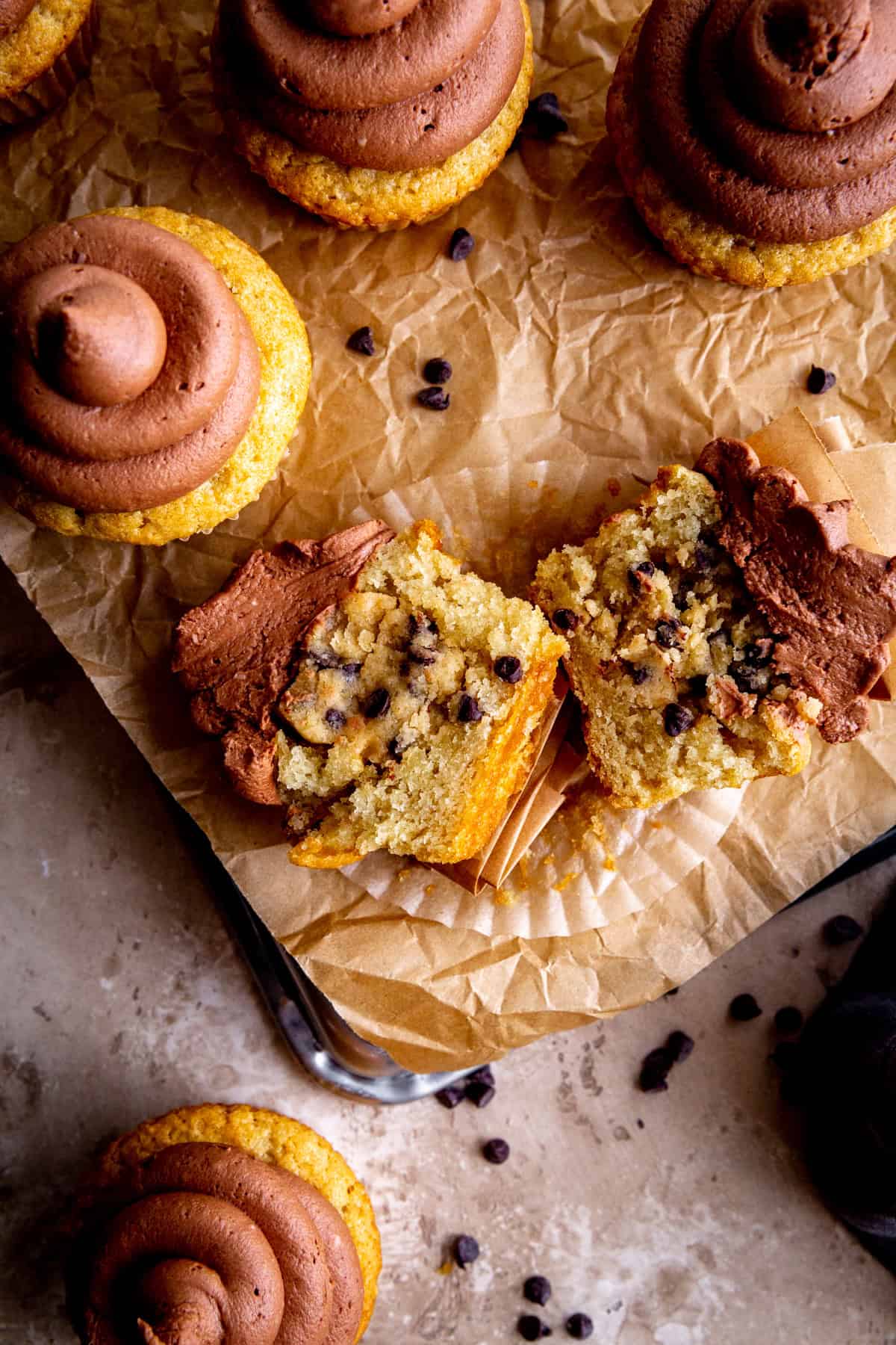 Cookie dough cupcake with chocolate frosting cut in half.