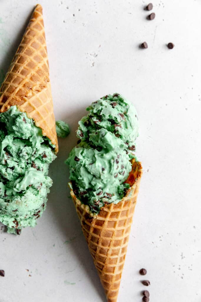 Two waffle cones of mint chip ice cream.