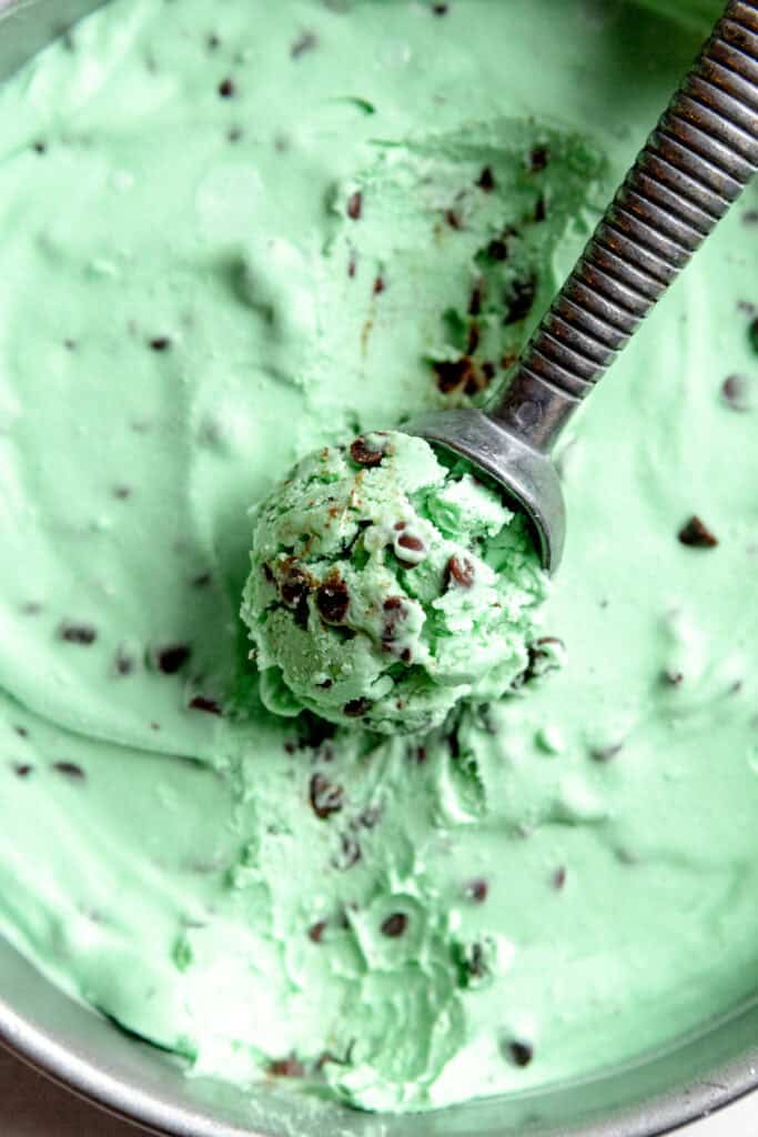 Metal ice cream scoop scooping mint chip ice cream.