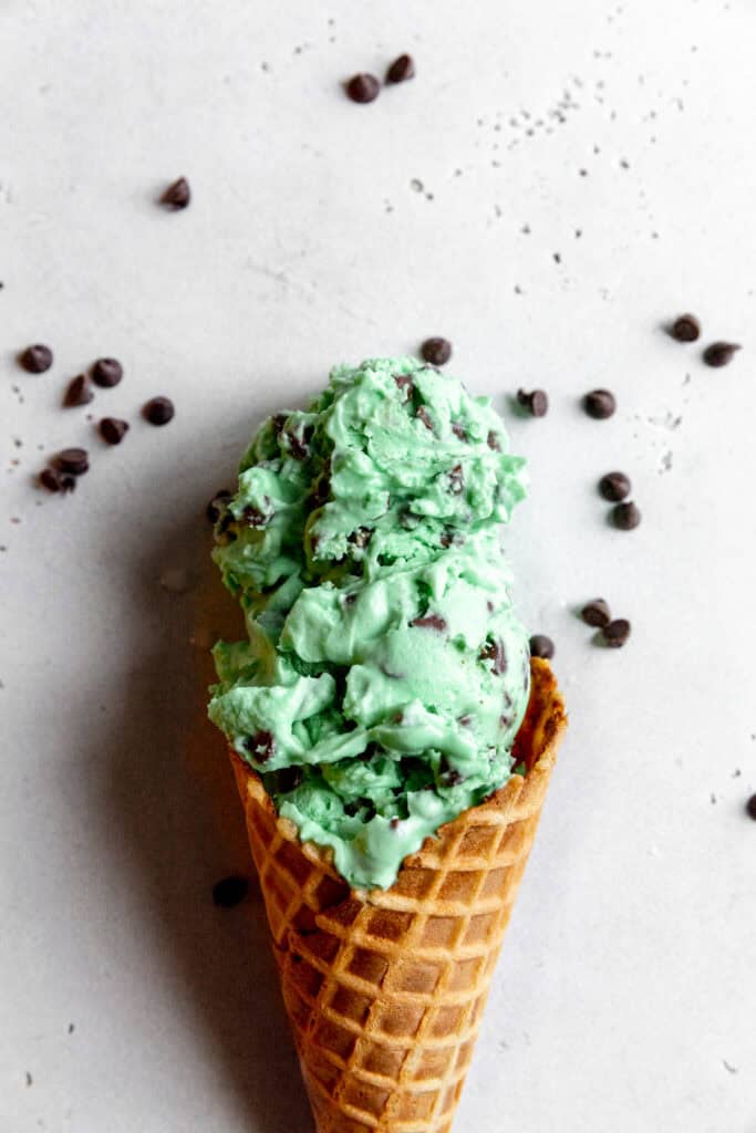 Waffle cone with two scoops of mit chip ice cream.