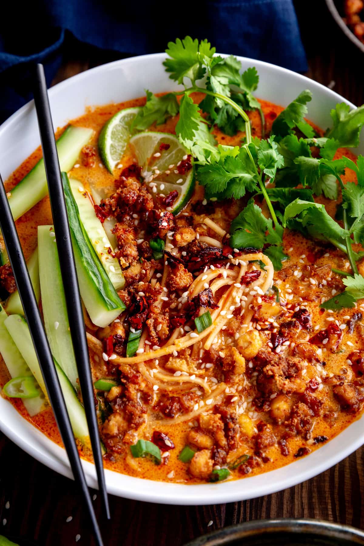Bowl of miso curry ramen topped with cilantro, cucumber and crispy tofu.