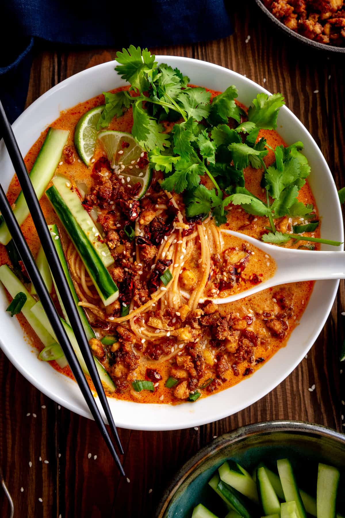 Large white spoon and chopsticks in a bowl of miso curry ramen.