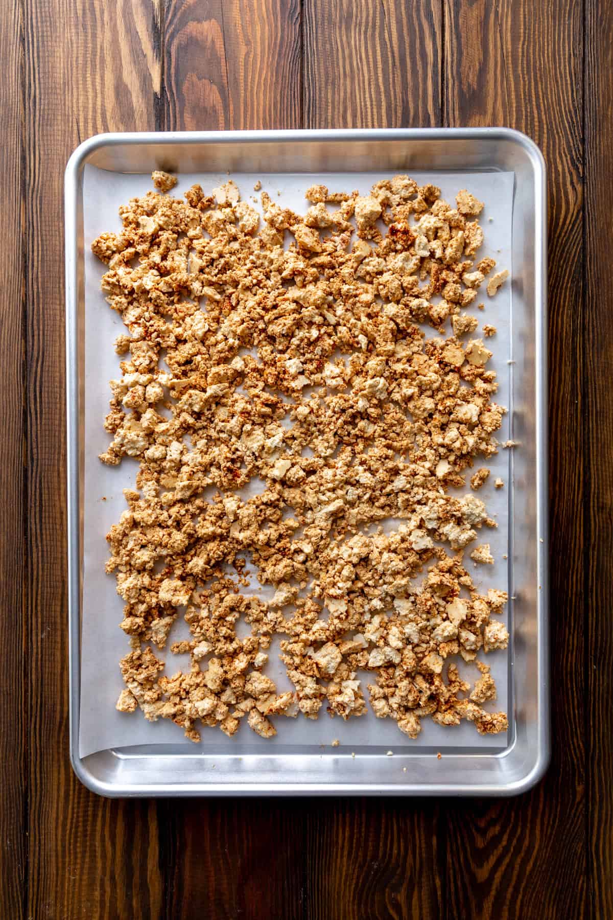 Unbaked tofu crumbles on a baking sheet.