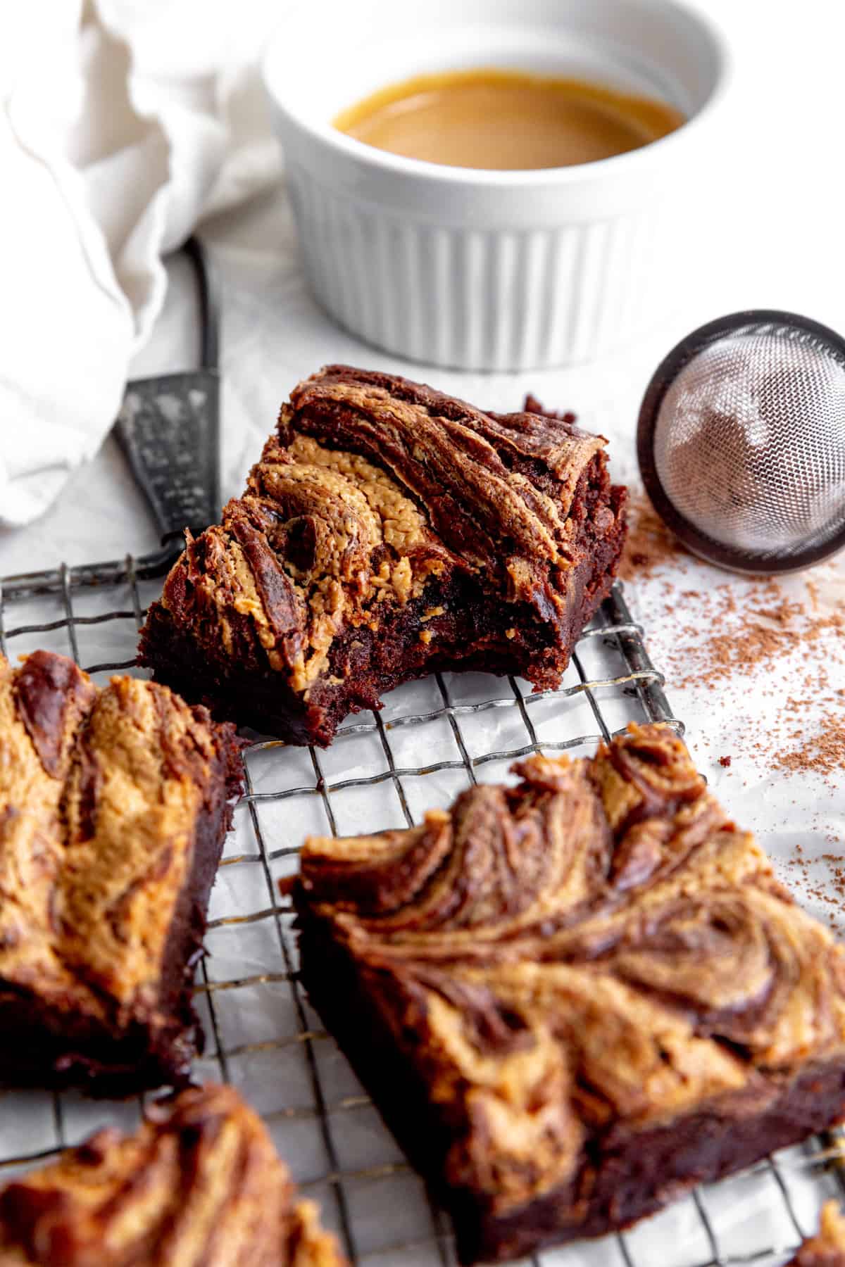 Peanut butter brownie with a bite taken out of it on a wire rack.